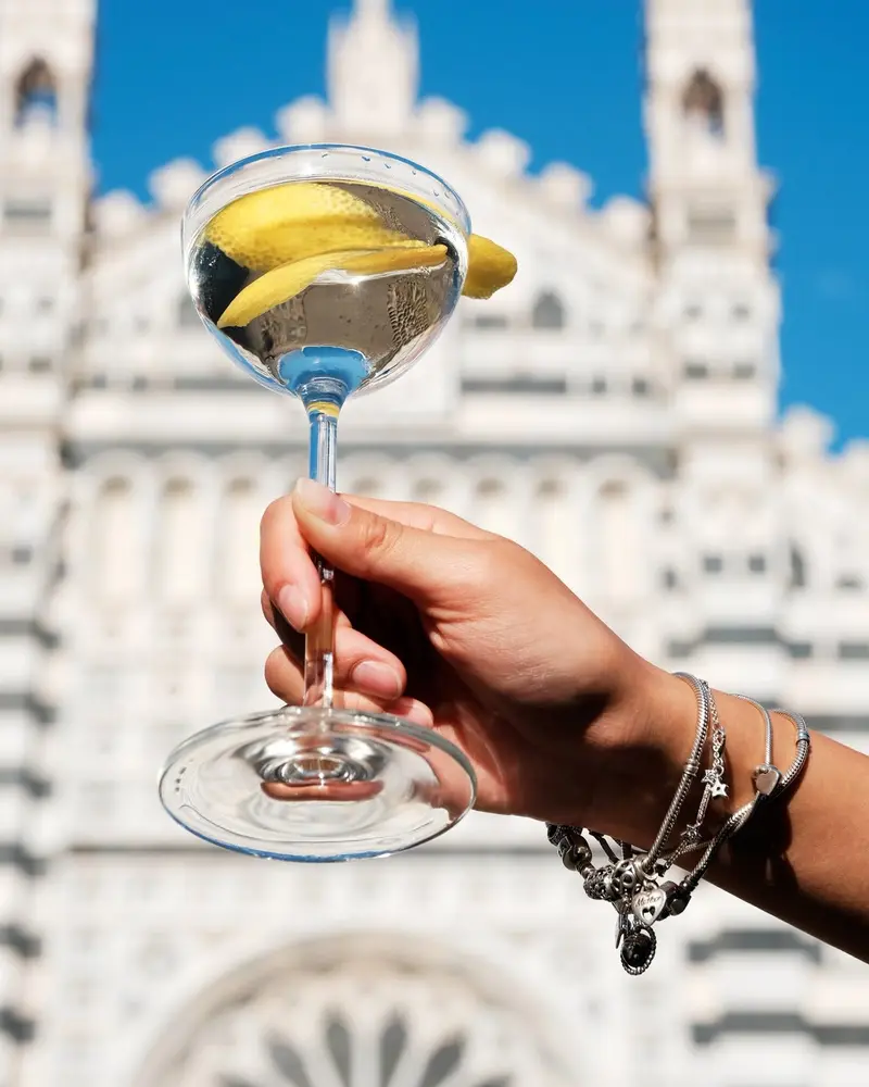 Una coppa in mano, il Duomo sfocato dietro.