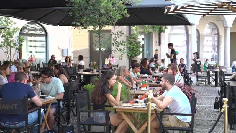 I tavoli di Saint in piazza, pieni di gente, sotto gli ombrelloni.