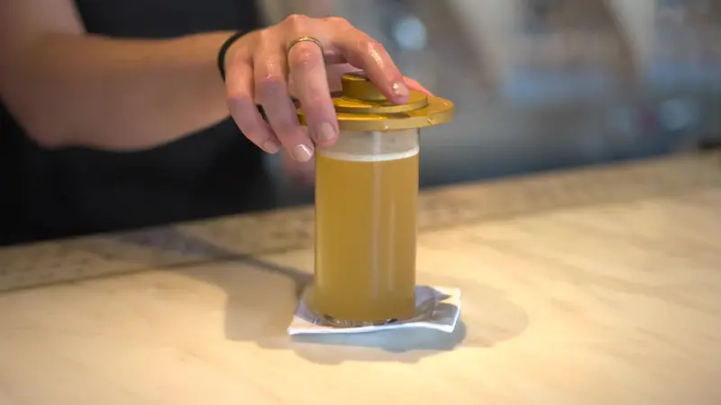 Un cocktail sotto un coperchio d'ottone, nel fumo.