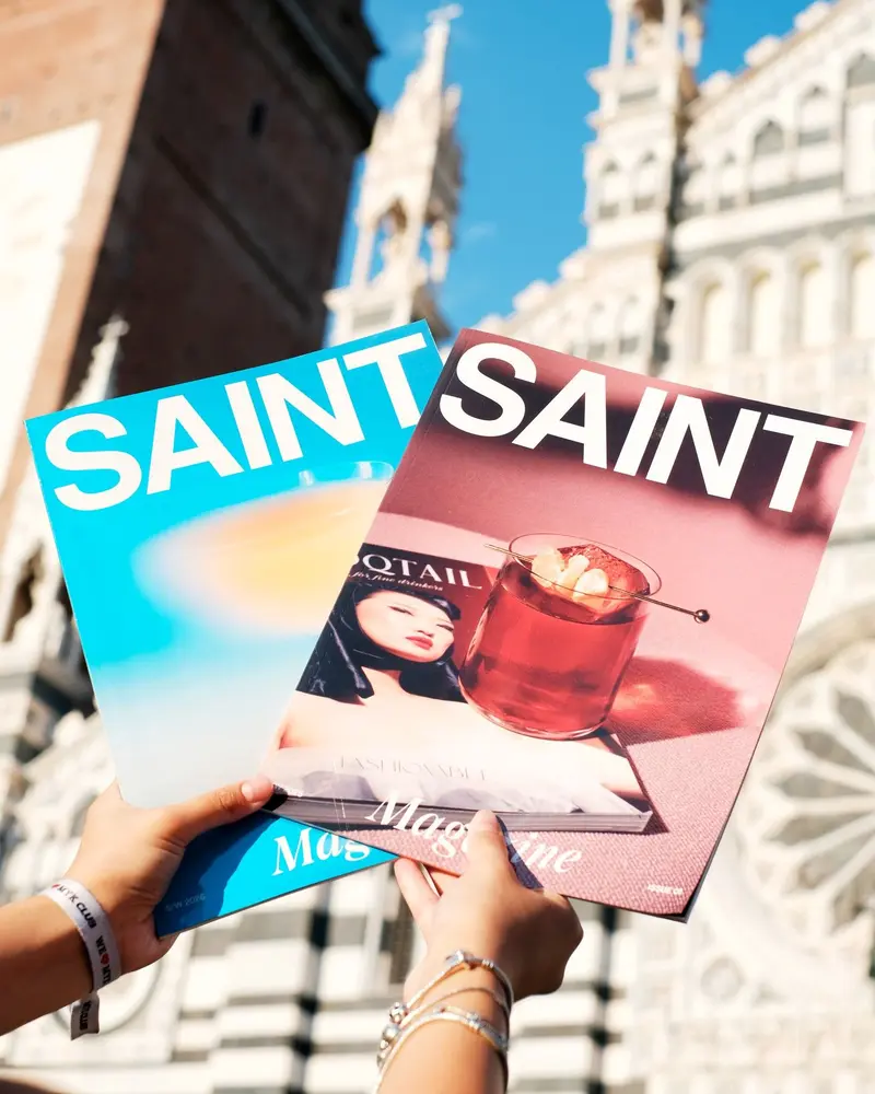 Le copertine del Saint Magazine tenute in mano davanti al Duomo.
